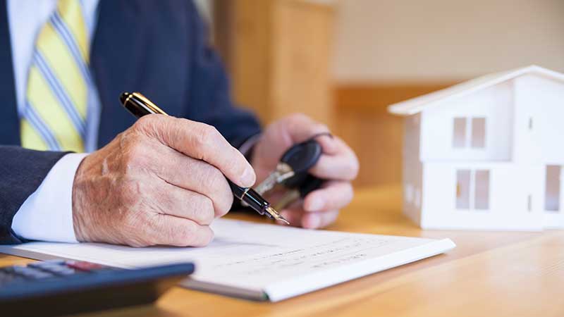 Homem a assinar documento